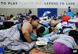 Annette Davis kisses her son Darius, 3, while staying at a shelter in Miami after evacuating from their home in Florida City, Fla., ahead of Hurricane Irma, Sept. 9, 2017.