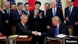 2020年1月15日中国副总理刘鹤与美国总统特朗普签署美中贸易“第一阶段”协定后握手。