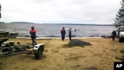 Para petugas penyelamat Rusia berada di lokasi tewasnya 14 anak peserta kamp musim panas di Danau Karelian, Rusia barat laut (19/6).