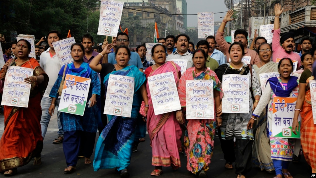 Activists of Trinamool Congress party hold banners and shout slogan during a protest march against the government's decision to withdraw high denomination notes from circulation, in Kolkata, India, Nov. 28, 2016. 