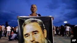 Seorang perempuan memegang foto Fidel Castro untuk menghormati pemimpin Kuba itu di lapangan Antonio Maceo di Santiago, Kuba, Sabtu, 3 Desember 2016.