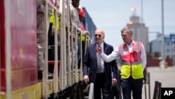 El presidente Joe Biden y el director de operaciones de Lobito Atlantic Railway, Nicolas Gregoire, recorren la terminal del puerto de Lobito en Lobito, Angola, el 4 de diciembre de 2024.