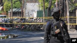 Seorang polisi berjaga-jaga di lokasi ledakan di Surabaya.