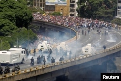 FILE - Demonstrators clash with riot police during the so-called "mother of all marches" against Venezuela's President Nicolas Maduro in Caracas, Venezuela, April 19, 2017.
