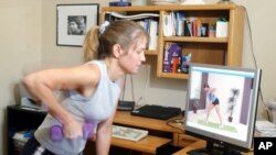 Michele Galindo exercises with a streaming video from a website while in her Austin, Texas, April 26, 2006. 