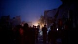 People near a damaged building after it was attacked by a Syrian Army jet in Azaz, Syria, December 16, 2012. 