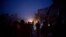 People near a damaged building after it was attacked by a Syrian Army jet in Azaz, Syria, December 16, 2012. 