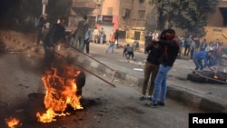 Para pendukung Ikhwanul Muslimin dan presiden Mesir tersingkir Mohamed Mursi menutup jalan dalam bentrokan dengan polisi di Kairo (25/1). (Reuters/Mohamed Abd El Ghany)