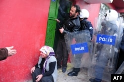 A woman, who has been exposed to tear gas, cries during clashes with Turkish police on December 8, 2013 in Diyarbakir, a day after the funerals of 34 year-old Veysel Isbilir and 32 year-old Mehmet Resit Isbilir were held in Yuksekova.