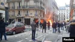 Warga berkumpul di dekat sebuah toko roti di mana ledakan yang diduga akibat ledakan gas terjadi di Paris, Perancis (12/1). 