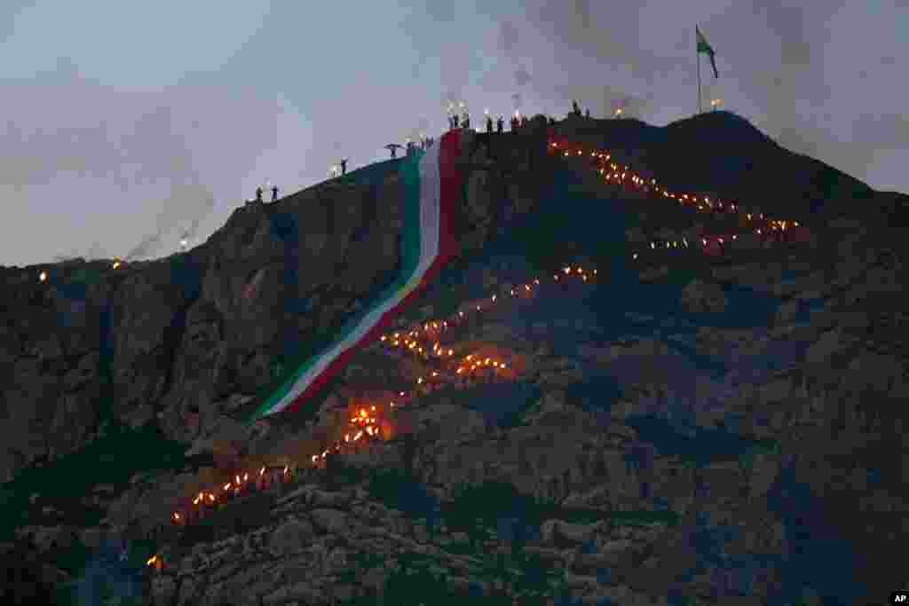 Iraqi Kurds with a giant banner in the colors of the Kurdish flag celebrate Nowruz, or the New Year, in Dahuk, 260 miles (430 kilometers) northwest of Baghdad, Iraq.