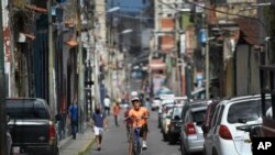 Un joven hace caballito en una bicicleta por las calles del barrio La Pastora de Caracas, Venezuela. Agosto 22, 2020.