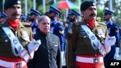 In this handout picture taken and released by Pakistan Prime Minister's Office on March 4, 2024, Pakistan's newly sworn-in Prime Minister Shehbaz Sharif (in dark suit) inspects the guard of honor at the Prime Minister House in Islamabad.