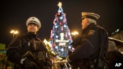 Armed police forces stand in front of the world's largest Christmas tree, according to the organizers, at the Christmas market in Dortmund, Nov. 27, 2017.