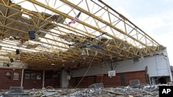 An American flag flies over the damaged gym at Henryville High School in Henryville, Indiana, March 3, 2012.