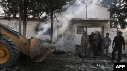 People gather at the site of a car bomb explosion in front the offices of a Turkey-backed group in the northern Syrian Kurdish town of Tal Abyad, on the border between Syria and Turkey, October 24, 2019.