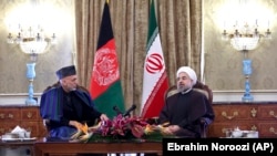 Presiden Iran Hassan Rouhani bersama Presiden Afghanistan Hamid Karzai dalam pertemuan di Teheran.