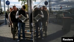 FILE - People wait in line to enter a government-run employment office in Madrid, Nov. 4, 2014.