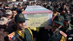 FILE - Civilians and armed forces members carry the flag-draped coffins of Iranian Revolutionary Guard Gen. Mohsen Ghajarian, foreground, and five soldiers who were killed in fighting in Syria, during their funeral outside the headquarters of the guard's ground forces, in Tehran, Iran, Feb. 6, 2016. 