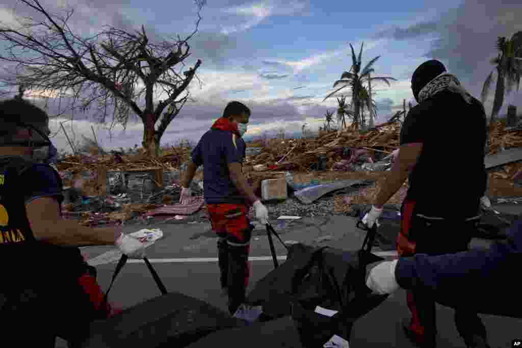 Members of a Philippines rescue team carry corpses in body bags as they search for the dead in Tacloban, central Philippines, Nov. 13, 2013. 