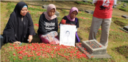 Pendamping, keluarga korban dan korban saat berziarah sambil melakukan tabur bunga di TPU Pondok Rangon, Jakarta, 13 Mei 2019. (Foto:VOA/ Sasmito)