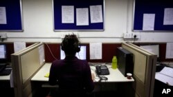 FILE - An Indian woman takes calls on a government hotline established in an effort to confront the country's appalling treatment of women, Dec. 2, 2013.