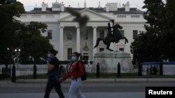 27일 미국 백악관 앞을 마스크를 착용한 시민들이 지나고 있다. 