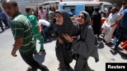 Palestinians react to what witnesses said was heavy Israeli shelling, at a hospital in Rafah in the southern Gaza Strip August 1, 2014.