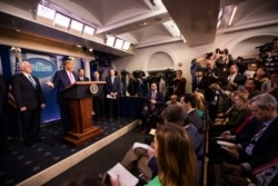 FILE - President Donald Trump, with Vice President Mike Pence, left, and members of the president's coronavirus task force, speaks during a news conference at the Brady press briefing room of the White House, Feb. 26, 2020.