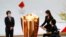 Tokyo 2020 President Seiko Hashimoto, left, watches Japanese actress Satomi Ishihara and Paralympian Aki Taguchi light the celebration cauldron on the first day of the Tokyo 2020 Olympic torch relay in Naraha, Fukushima prefecture, northeastern Japan, Thu