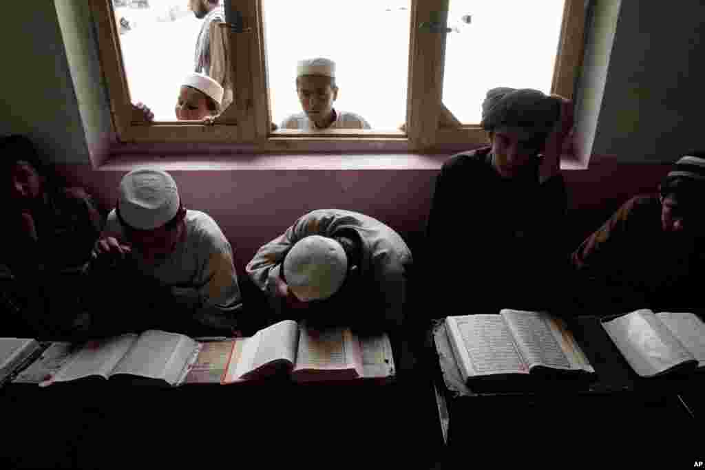 Boys read the Quran during the Muslim holy month of Ramadan at a mosque on the outskirts of Kabul, Afghanistan, July 16, 2013.