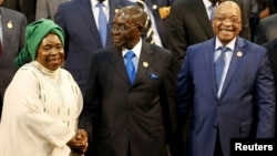 FILE: Chairperson of the African Union (AU) Commission Nkosazana Dlamini-Zuma (L) smiles as she is greeted by Zimbabwe's President Robert Mugabe next to South Africa's president Jacob Zuma ahead of the 25th African Union summit in Johannesburg, June 14, 2015. 