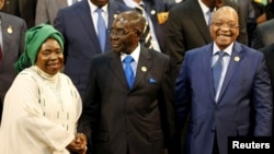 Chairperson of the African Union (AU) Commission Nkosazana Dlamini-Zuma (L) smiles as she is greeted by Zimbabwe's President Robert Mugabe next to South Africa's president Jacob Zuma ahead of the 25th African Union summit in Johannesburg, June 14, 2015.