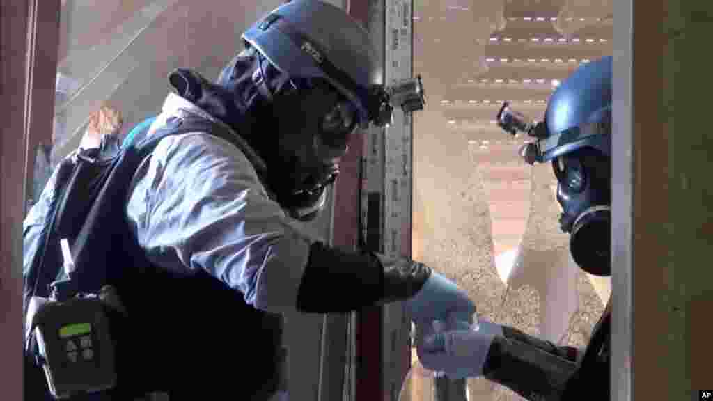 In this image taken from video obtained from the Shaam News Network, U.N. investigators gather potential evidence in a Damascus suburb, August 28, 2013.