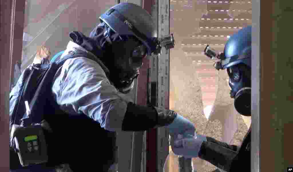 In this image taken from video obtained from the Shaam News Network, U.N. investigators gather potential evidence in a Damascus suburb, August 28, 2013.
