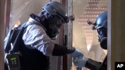 In this image taken from video obtained from the Shaam News Network, U.N. investigators take samples from a Damascus suburb, August 28, 2013.