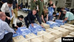 联合国军指挥部和美国国防部人员在朝鲜交给美国的遗骸木箱上覆盖联合国旗 - 资料照片