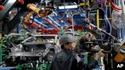 FILE - A worker checks a new assembly line at the Ford Hai Duong production facility in Hai Duong, Vietnam.