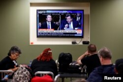 People watch U.S. Supreme Court nominee Brett Kavanaugh testify to the Senate Judiciary Committee in Washington, Sept. 27, 2018.
