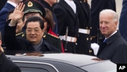 Chinese President Hu Jintao, accompanied by Vice President Joe Biden, waves during the arrival ceremony, Tuesday, Jan. 18, 2011, at Andrews Air Force Base, outside Washington.