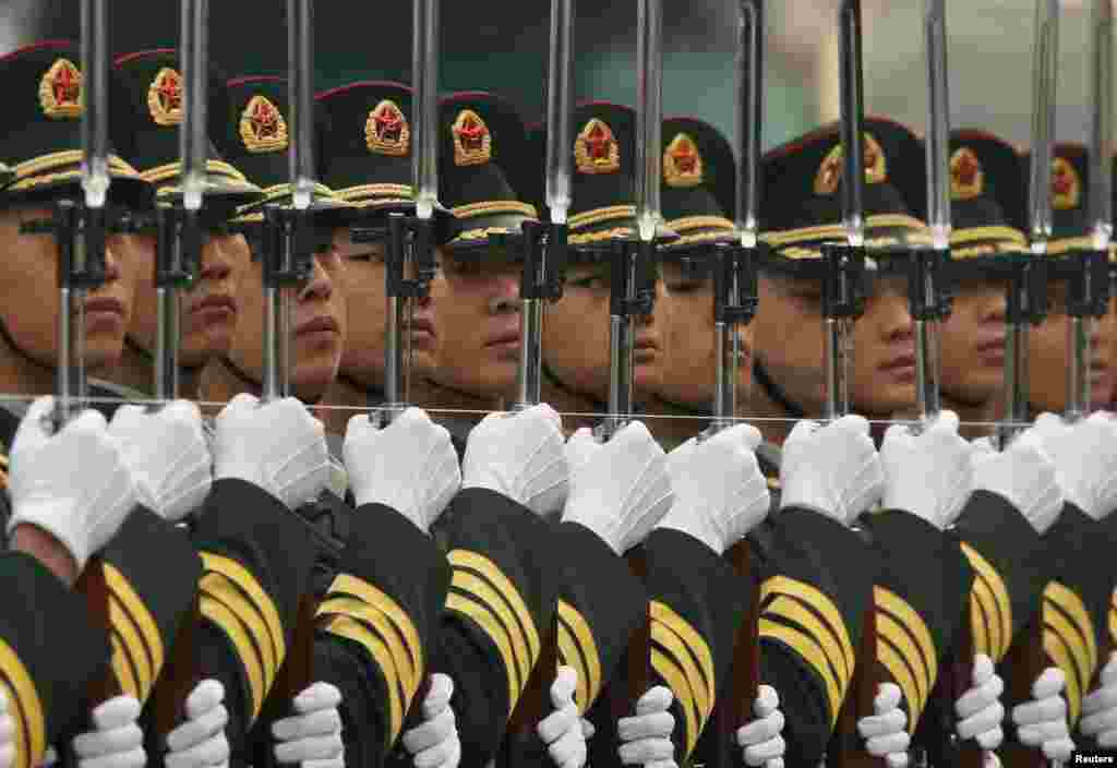 Members of the honor guard use a string to ensure that they are standing in a straight line outside the Great Hall of the People in Beijing, China.