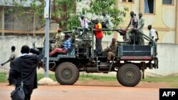 A man watches a truck with former Seleka coalition rebels drive by on Oct. 7, 2013 in Bangui, Central African Republic.