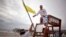 Tybee Island Ocean Rescue Senior Lifeguard Todd Horne, right, and Mark Eichenlaub, left, hang a yellow flag that warns swimmer of strong rip currents from Hurricane Arthur along the beach, on Tybee Island, Georgia, July 3, 2014. 