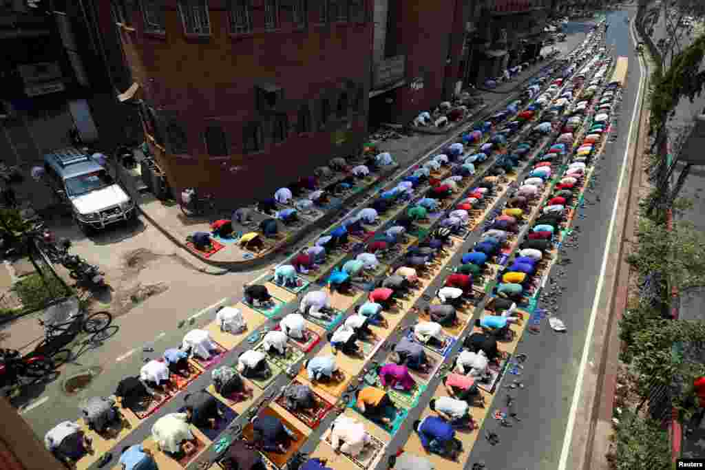 Muslims take part in Friday prayer as part of the holy fasting month of Ramadan on the street in front of a mosque amid the coronavirus pandemic, in Dhaka, Bangladesh.