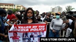 Une dame porte une pancarte lors de manifestations pour demander la suppression de l'unité de police controversée SARS à Ikeja, le 9 octobre 2020. (Photo: PIUS UTOMI EKPEI / AFP)