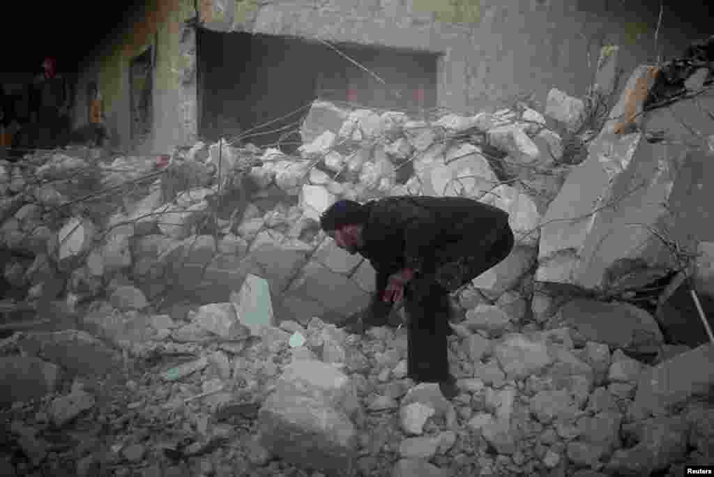 A man searches for survivors after an air strike in Azaz city, North Aleppo, December 29, 2012. 