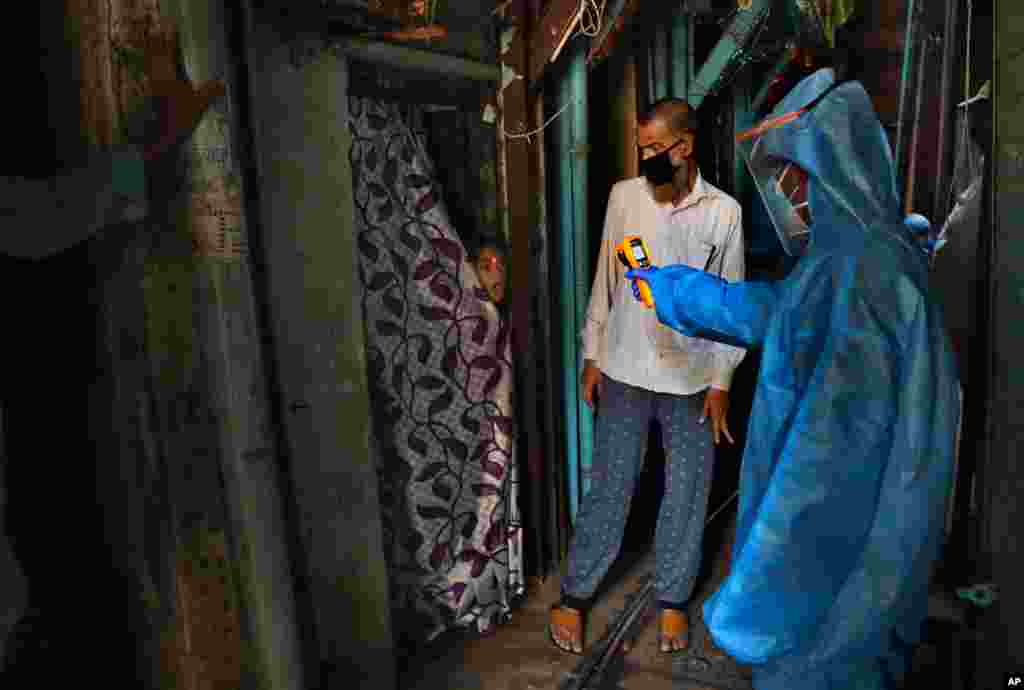 A doctor checks the temperature of a girl in Dharavi, one of Asia&#39;s largest slums, during lockdown to prevent the spread of the new coronavirus in Mumbai, India.
