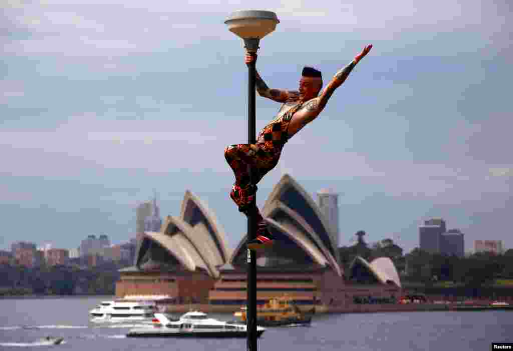 Performer Mitch Jones from Circus Oz reacts after climbing a light pole during the official launch of the annual cultural celebration The Sydney Festival, which showcases theater, dance, circus, visual art and music during the month of January, in a park opposite the Sydney Opera House in Australia.