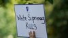 Seorang perempuan membawa poster bertuliskan "Supremasi Kulit Putih Membunuh" dalam aksi protes di depan Gedung Putih, Washington, pada 6 Agustus 2019. (Foto: Reuters/Kevin Lamarque)