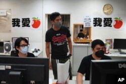 Los miembros del personal diseñan las páginas de la última edición de Apple Daily en la sede del periódico en Hong Kong, el 23 de junio de 2021.